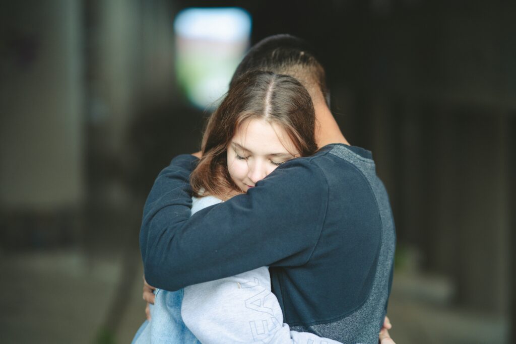 a couple of people that are hugging each other